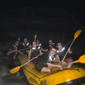 Grupo no bote amarelo durante o Rafting Noturno no Rio Jacaré Pepira em Brotas