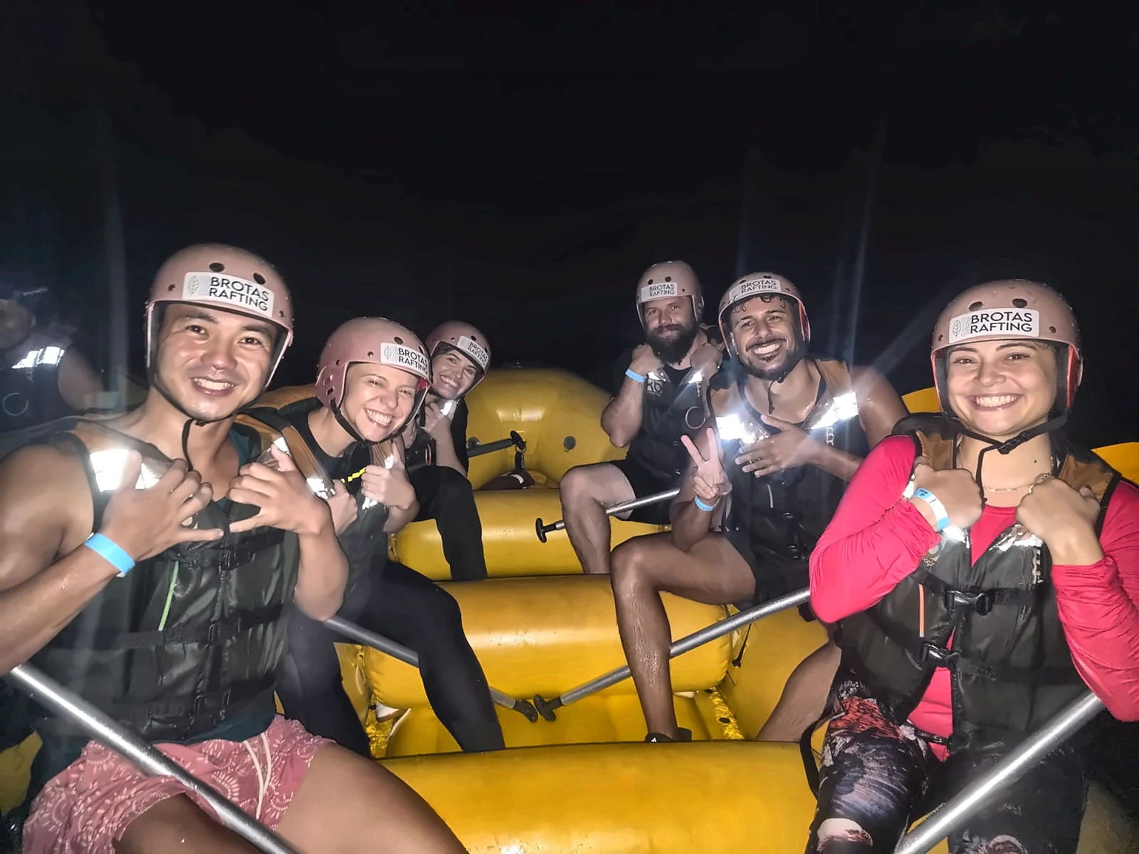 Group smiling in the boat during Night Rafting in Brotas