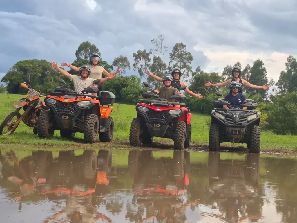 Grupo em quadriciclos com reflexo na água durante o roteiro de 18 km em Brotas