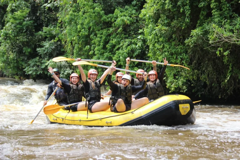 Group with a participant with a leg amputation raising paddles in the rafting boat on the Jacaré-Pepira River in Brotas