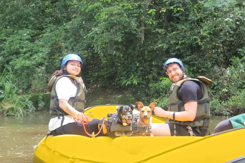 Rafting Pet em Brotas: casal com dois cachorros de colete no bote